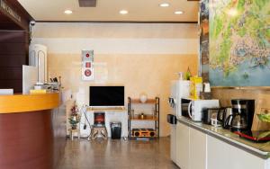 a kitchen with a refrigerator and a tv in a room at Mo-A Motel in Sokcho