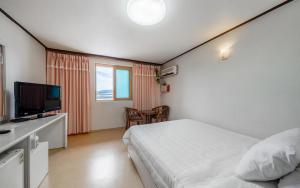 a bedroom with a bed and a flat screen tv at Mo-A Motel in Sokcho +7 photos