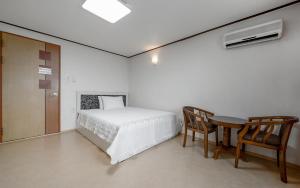 a bedroom with a bed and a desk and a table at Mo-A Motel in Sokcho