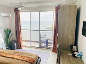 a bedroom with a view of the ocean at SunSeaBar Beach Resort in Kendwa