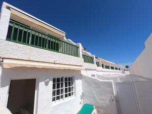 a white building with a green balcony on top of it at Apartamentos Guanarama in Puerto del Carmen +3 photos