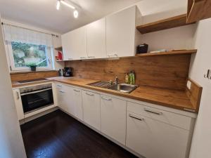 a kitchen with white cabinets and a sink at Ferienwohnung Zürcher in Chieming