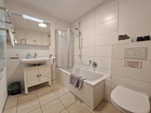 a bathroom with a tub and a sink and a toilet at Ferienwohnung Zürcher in Chieming