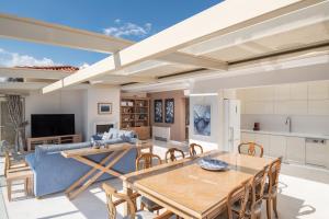 a kitchen and living room with a table and chairs at La Mer Escape in Nikiti