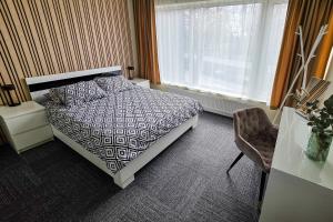 a bedroom with a bed and a desk and a window at Weekend apartment 3 in Sigulda