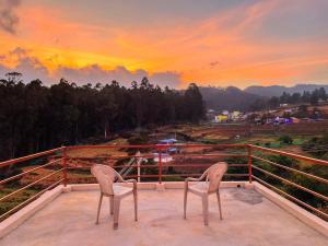 two chairs sitting on a balcony with a sunset at The Storyhouse in Kūkkāl +10 photos