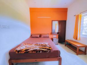 a bed in a room with an orange wall at The Storyhouse in Kūkkāl