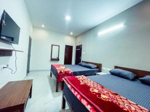 a hotel room with two beds and a tv at The Storyhouse in Kūkkāl