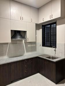 a kitchen with white cabinets and a sink at Sai Sea Groups in Covelong