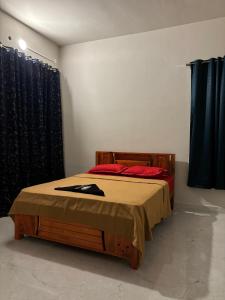 a bedroom with a bed with red pillows at Sai Sea Groups in Covelong