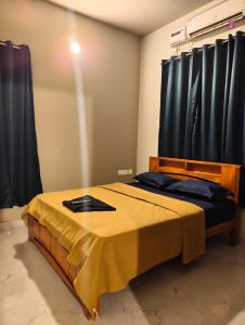 a bedroom with a bed with a yellow blanket on it at Sai Sea Groups in Covelong
