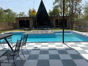a swimming pool with a table and chairs next to a swimming pool at The triangle haven escape in Ani +20 photos