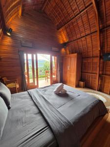 a large bed in a room with a large window at My Lodge Bedugul in Bedugul