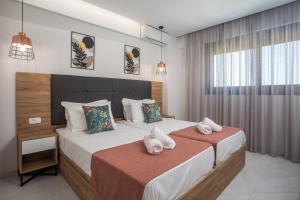 a bedroom with two beds with towels on them at Calma Luxury Villas in Kolymbia +72 photos