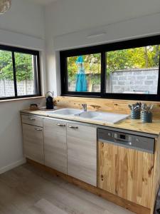 a kitchen with a sink and two windows at Le rivage 44 in Bénouville