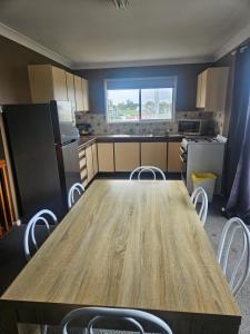 a kitchen with a wooden table and white chairs at Rockhampton Court Apartment in Rockhampton
