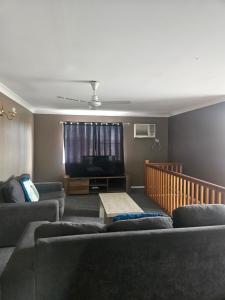 a living room with two couches and a flat screen tv at Rockhampton Court Apartment in Rockhampton