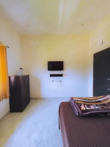 a bedroom with a bed and a tv on the wall at The Storyhouse in Kūkkāl
