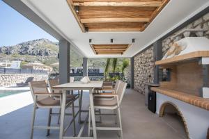 an outdoor kitchen and dining area with a table and chairs at Calma Luxury Villas in Kolymbia