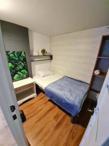a small room with two beds and a wooden floor at Hostel Caps Home in Astana