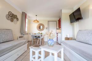 a living room with a couch and a table at L'Esquirou in Biscarrosse