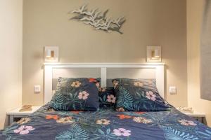 a bedroom with a bed with a headboard and pillows at L'Esquirou in Biscarrosse