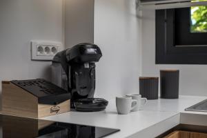 a coffee maker sitting on a counter with two cups at Calma Luxury Villas in Kolymbia