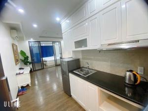 a kitchen with white cabinets and a black counter top at Khách sạn QUEENIE in Hai Phong +41 photos