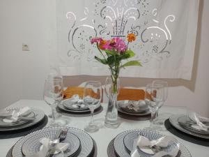 a table with plates and a vase with flowers in it at Villa Makris in Zenempisátika