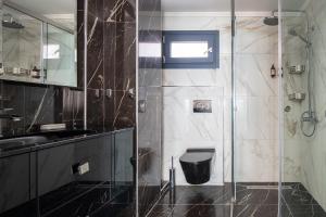a bathroom with a glass shower and a toilet at La Mer Escape in Nikiti +45 photos
