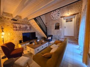 a living room with a couch and a tv at La Colline Truffière in Sourzac