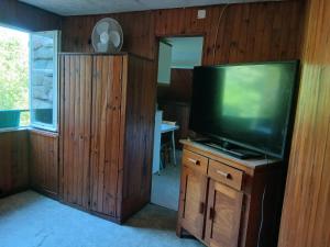 a living room with a flat screen tv on a wooden wall at Studio privatif in Figeac