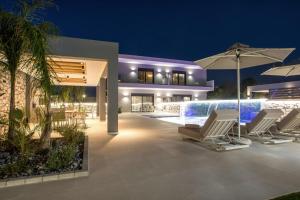 a villa with a swimming pool at night at Calma Luxury Villas in Kolymbia