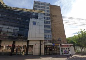 a tall building with people walking in front of it at Emanuela Home in Piatra Neamţ