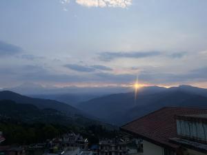 a view of a mountain valley with the sun setting in the distance at Subhechchha Hotel in Charikot