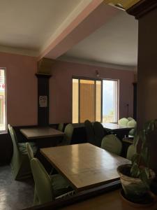 a room with chairs and tables and a table and a table and a window at Subhechchha Hotel in Charikot