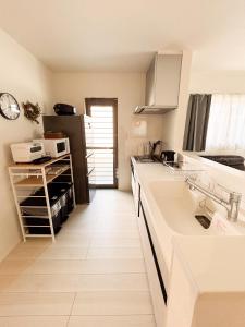 a kitchen with a sink and a counter top at 新築一棟貸切 民宿 夢 駐車場2台無料 コンビニ徒歩2分 市街地へ好アクセス in Matsuyama