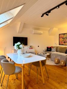 a living room with a white table and chairs at Landhaus Wulfenia - APARTMENT KLAGENFURT - Private Sauna, Smart-TV, Air Conditioning, Free Parking in Klagenfurt +38 photos