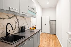 a kitchen with a sink and a refrigerator at Platinum Prestige Residence in Rybnik