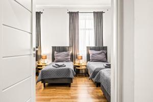a bedroom with two beds and a window at Platinum Prestige Residence in Rybnik