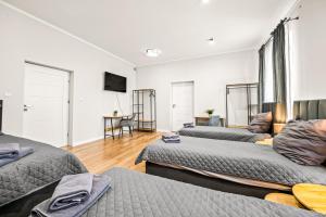 a room with three beds and a flat screen tv at Platinum Prestige Residence in Rybnik