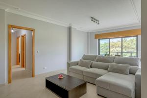 a living room with a couch and a coffee table at 2-Bed Vialonga Vista Apartment in Lisbon
