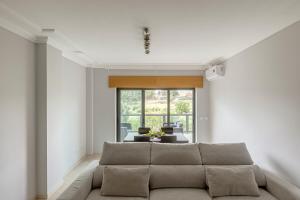 a living room with a couch and a table at 2-Bed Vialonga Vista Apartment in Lisbon