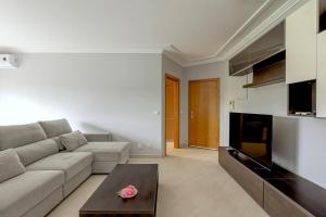 a living room with a couch and a table at 2-Bed Vialonga Vista Apartment in Lisbon