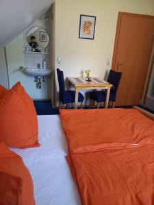 a room with a bed and a table with orange pillows at Privatzimmer Daniela und Hubert Gosch in Mixnitz