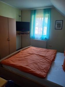a bed in a bedroom with a blue window at Privatzimmer Daniela und Hubert Gosch in Mixnitz