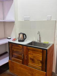 a kitchen sink with a tea kettle on top of it at The Tamarind Villa in Kandy +2 photos