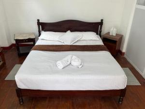 a bed with two pairs of slippers on it at The Tamarind Villa in Kandy