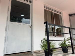 a white door on a house with two potted plants at The Tamarind Villa in Kandy