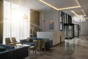 eine Lobby mit blauen Sofas, einem Tisch und Stühlen in der Unterkunft Radisson Hotel Madinah in Medina + 74 Fotos